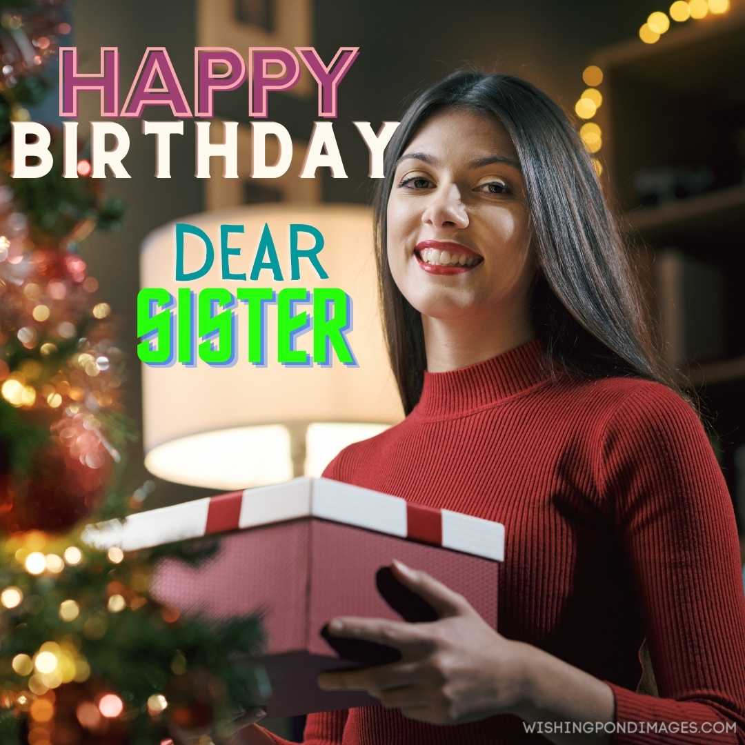 A beautiful woman holding a gift and smiling. Happy Birthday Sister Images